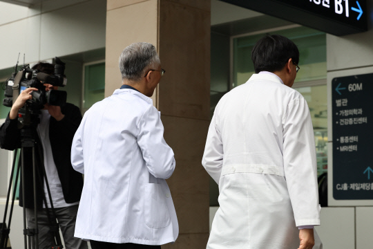 총회가 열리는 23일 오후 서울의대 교수가 회의실이 위치한 서울대학교병원 어린이병원 건물로 들어서고 있다. [연합뉴스]